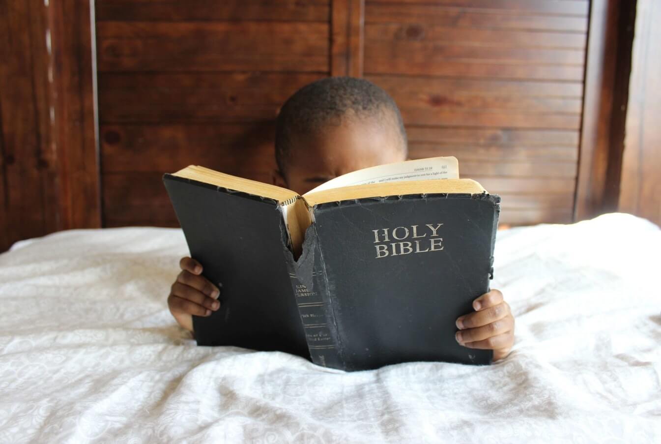 A child reading a Holy Bible