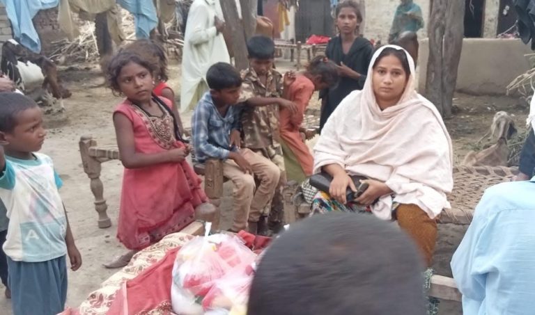 A mother and children in a village in Pakistan during a Bible and supplies distribution